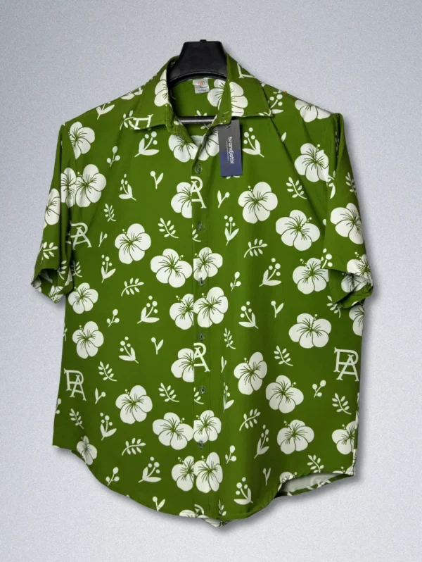 Men's FPS Apparel Tropical Monogram Silk Shirt, a green short-sleeve button-down with a white floral print and a subtle FPS logo pattern.