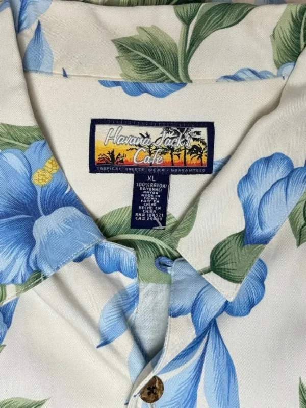 Men's Havana Jack's Cafe Hawaiian Shirt, a light-colored short-sleeve button-down with a blue hibiscus floral print.