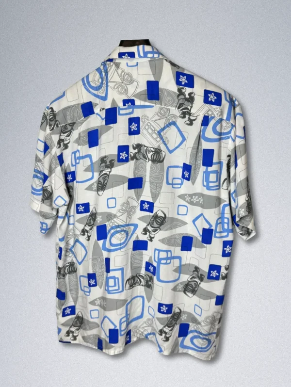 Pineapple Connection Rayon Shirt - Men's short-sleeve button-down with an abstract print of blue squares, gray shapes, and stylized tiki masks and surfboards on a white background.