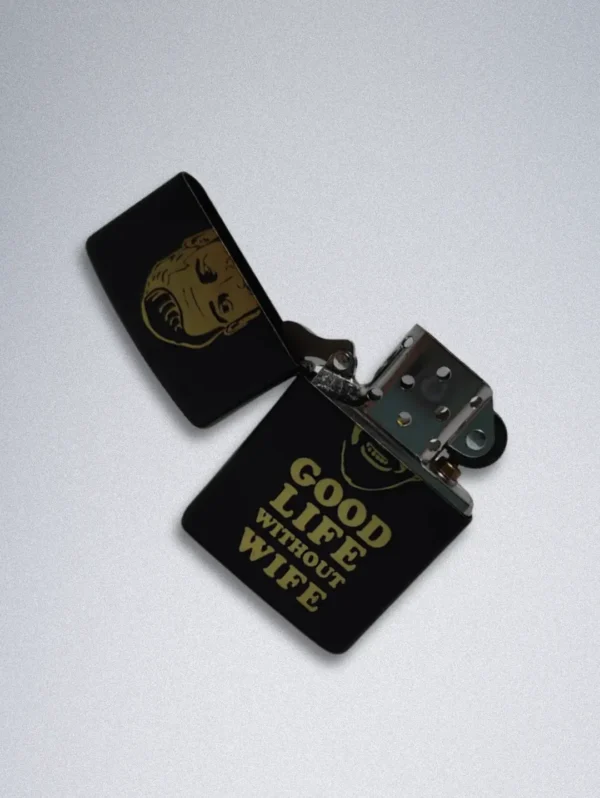 A matte black Zippo lighter with a gold graphic of a smiling, bearded man and the text "GOOD LIFE WITHOUT WIFE".