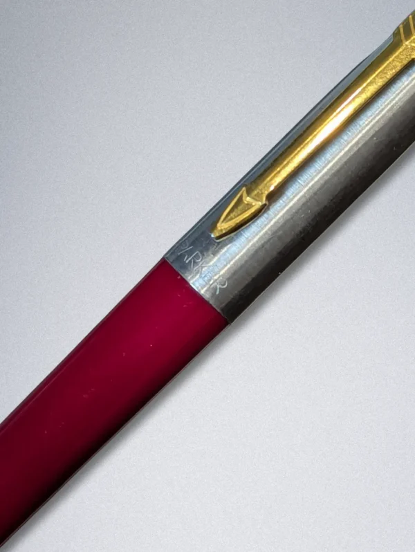 Genuine Parker ballpoint pen with a burgundy barrel, stainless steel cap, and gold arrow clip.