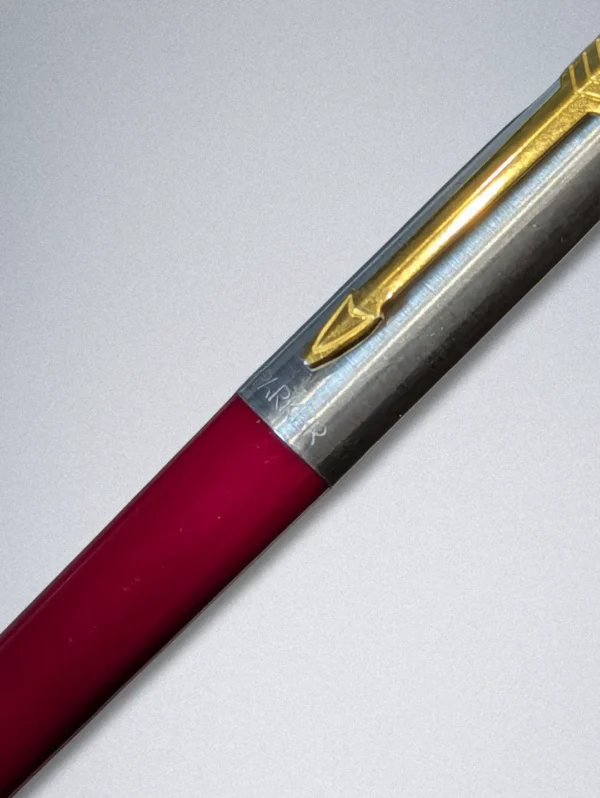 Genuine Parker ballpoint pen with a burgundy barrel, stainless steel cap, and gold arrow clip.